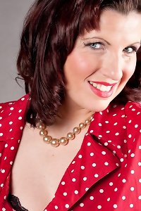 blond milf in stockings and heels is laying on the bed